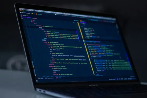 Laptop screen showing lines of programming code, representing EDI claim files and clearinghouse rejection reports