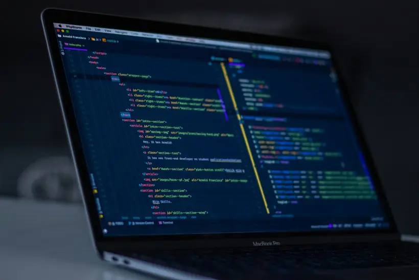 Laptop screen showing lines of programming code, representing EDI claim files and clearinghouse rejection reports