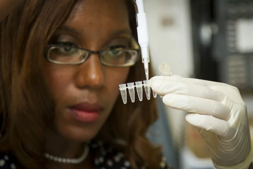 Researcher working with lab samples and documentation, representing clinical trial billing and Medicare coverage analysis