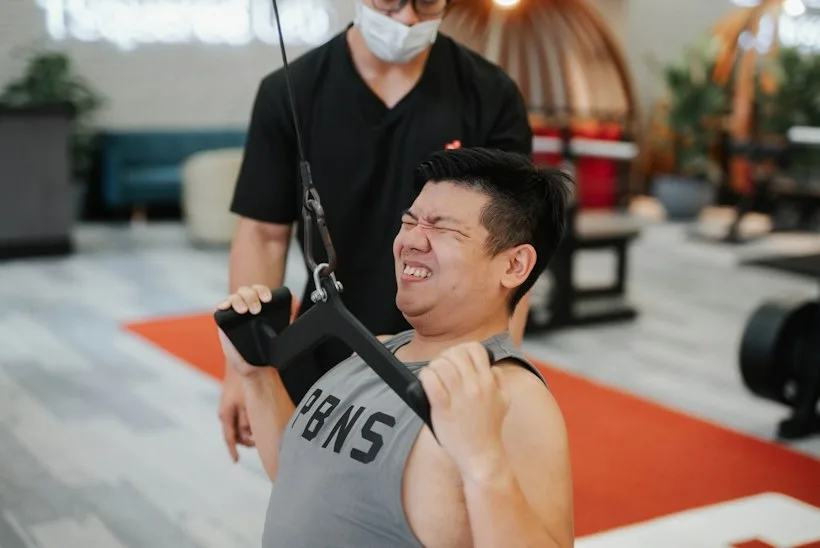 Physical therapist assisting a patient with mobility exercises, representing inpatient rehabilitation facility therapy documentation