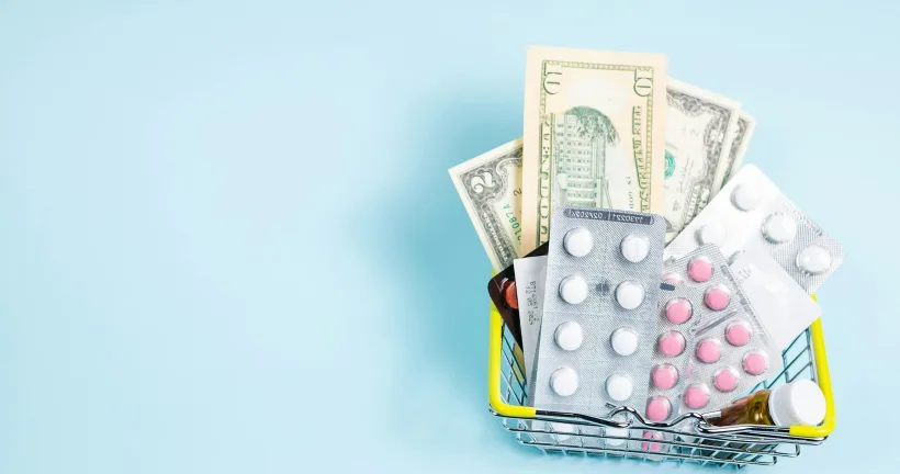 US dollar bills and medication in a shopping basket, representing patient collections and self-pay medical billing