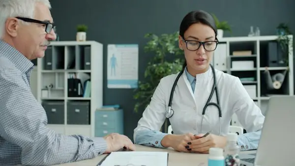 Primary care doctor consulting with an elderly patient, representing advanced primary care management billing